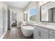 Bright main bathroom features a soaking tub, double vanity, separate shower, and wood-look flooring at 4365 Frontera Ln, Wesley Chapel, FL 33543