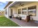 Inviting outdoor patio featuring a wicker seating area, ceiling fan, and well-maintained lawn at 4365 Frontera Ln, Wesley Chapel, FL 33543