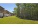 Townhome exterior showcasing a spacious backyard with lush green grass and mature trees at 4535 Winding River Way, Land O Lakes, FL 34639