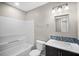 Bathroom featuring a single sink vanity with granite counters, tub-shower combo and modern fixtures at 4535 Winding River Way, Land O Lakes, FL 34639
