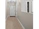 Hallway featuring neutral walls and tile flooring, with a contemporary light fixture and multiple doorways at 4535 Winding River Way, Land O Lakes, FL 34639
