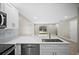 The kitchen features stainless steel appliances, white cabinets, and seamless flow to the living area at 4535 Winding River Way, Land O Lakes, FL 34639