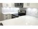 Modern kitchen with white cabinetry, stainless steel appliances, and mosaic tile backsplash at 4535 Winding River Way, Land O Lakes, FL 34639