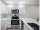 Modern kitchen with white cabinets, stainless steel appliances, and stylish backsplash at 4535 Winding River Way, Land O Lakes, FL 34639