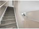 View of staircase with carpet runner and an open concept floor plan leading to the kitchen area at 4535 Winding River Way, Land O Lakes, FL 34639
