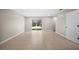 Spacious living room with neutral walls, tiled flooring, and sliding glass doors to the backyard at 4535 Winding River Way, Land O Lakes, FL 34639