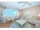 Bright living room with water view, floral curtains, rattan chairs, and comfortable seating arrangement at 4550 Cove Cir # 502, St Petersburg, FL 33708
