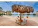 Unique tiki hut covering a picnic table in a patio area with a beautiful waterfront and condo backdrop at 4550 Cove Cir # 502, St Petersburg, FL 33708