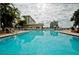Expansive community pool with lounge chairs, umbrellas, and condo buildings providing a relaxing atmosphere at 4550 Cove Cir # 502, St Petersburg, FL 33708