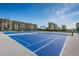 Bright blue tennis courts offering recreational opportunities with surrounding views of residences and palm trees at 4550 Cove Cir # 502, St Petersburg, FL 33708
