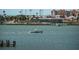 View of boat on sparkling water with buildings and palm trees along the shore at 4550 Cove Cir # 502, St Petersburg, FL 33708