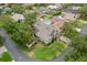 Aerial view of a home with a green lawn and pool, surrounded by lush landscaping and other homes at 5269 White Sand Ne Cir, St Petersburg, FL 33703
