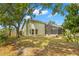 View of backyard with screened-in porch, grass and trees, offering a serene outdoor living space at 5269 White Sand Ne Cir, St Petersburg, FL 33703