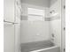 Bathroom featuring white tile walls surrounding a tub and shower, with neutral trim and accents at 5269 White Sand Ne Cir, St Petersburg, FL 33703