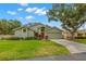 Well-manicured single-story home showcasing lush landscaping, mature trees, and a two-car garage in a serene setting at 5269 White Sand Ne Cir, St Petersburg, FL 33703