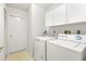 Functional laundry room featuring a washer, dryer, and storage cabinets at 5269 White Sand Ne Cir, St Petersburg, FL 33703