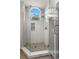 Bathroom featuring tile shower, decorative window and sleek glass door at 5269 White Sand Ne Cir, St Petersburg, FL 33703