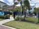 Outdoor community area with a pergola and picnic table, surrounded by a well-manicured lawn and black metal fence at 5768 75Th N Ter, Pinellas Park, FL 33781