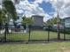 Exterior view of the community featuring a fenced green space with palm trees and modern, colorful homes at 5768 75Th N Ter, Pinellas Park, FL 33781