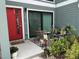 Charming front porch with cozy seating area, plant decorations, and a vibrant red door, welcoming visitors at 5768 75Th N Ter, Pinellas Park, FL 33781