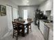 Functional kitchen boasts white cabinets, stainless steel appliances, a dining area, and access to outdoor space at 5768 75Th N Ter, Pinellas Park, FL 33781