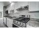 Close up view of kitchen featuring a stainless steel oven, range hood, and granite countertops at 5768 75Th N Ter, Pinellas Park, FL 33781