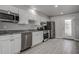 Modern kitchen featuring stainless steel appliances, gray granite countertops, and ample white cabinet space at 5768 75Th N Ter, Pinellas Park, FL 33781