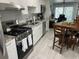 Functional kitchen boasts white cabinets, stainless steel appliances, a dining area, and access to outdoor space at 5768 75Th N Ter, Pinellas Park, FL 33781