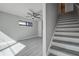 Bright living room with stairs, featuring gray vinyl floors and a modern ceiling fan at 5768 75Th N Ter, Pinellas Park, FL 33781