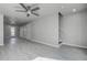 Spacious living room with gray floors, a modern ceiling fan, and ample natural light from the front door at 5768 75Th N Ter, Pinellas Park, FL 33781
