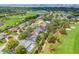 Panoramic aerial view showcases the property's location on a lush golf course with a glimpse of the bay at 634 Poinsettia Rd, Belleair, FL 33756