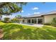 Spacious backyard featuring a modern home with a pool and manicured lawn at 634 Poinsettia Rd, Belleair, FL 33756
