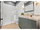 Elegant bathroom featuring a shower with white tile and a vanity with a marble countertop and olive-green cabinetry at 634 Poinsettia Rd, Belleair, FL 33756