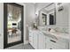 Elegant bathroom featuring a marble countertop, white cabinetry, and access to an outdoor living space at 634 Poinsettia Rd, Belleair, FL 33756