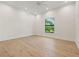 Bright bedroom with hardwood floors, a large window, and white walls at 634 Poinsettia Rd, Belleair, FL 33756