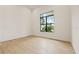 Empty bedroom with hardwood floors, a large window, and white walls at 634 Poinsettia Rd, Belleair, FL 33756