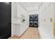 Well-equipped laundry room featuring modern stacked washer and dryer units, ample storage, and a stylish sink area at 634 Poinsettia Rd, Belleair, FL 33756
