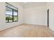 Bright room with hardwood flooring, wainscoting, and a large picture window offering scenic views at 634 Poinsettia Rd, Belleair, FL 33756