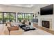 Bright living room features a fireplace, large windows, and comfortable seating for relaxing or entertaining at 634 Poinsettia Rd, Belleair, FL 33756