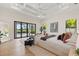 Bright main bedroom featuring tray ceilings, hardwood floors, and sliding doors to the outdoor pool area at 634 Poinsettia Rd, Belleair, FL 33756