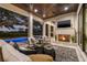 Covered outdoor living area with fireplace, comfortable seating, and pool views at 634 Poinsettia Rd, Belleair, FL 33756