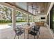 This covered patio has an outdoor kitchen and overlooks a pool and a lush landscaped yard at 634 Poinsettia Rd, Belleair, FL 33756