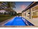 Inviting backyard oasis with a sparkling pool, lounge chairs, and a covered outdoor living space for relaxation at 634 Poinsettia Rd, Belleair, FL 33756