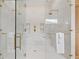 Bright walk-in shower featuring marble tile, dual shower heads, a built-in bench, and glass door and walls at 634 Poinsettia Rd, Belleair, FL 33756
