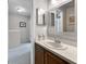 Well-maintained bathroom with a vanity and sink, framed mirrors, and a doorway, offering a clean and functional space at 7508 Hollowell Dr, Tampa, FL 33615
