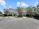 Townhouse exterior displaying multiple units with assigned parking spaces and mature trees at 7508 Hollowell Dr, Tampa, FL 33615