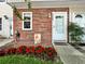 Inviting front entrance with red brick, vibrant flowers, and a charming welcome sign at 7508 Hollowell Dr, Tampa, FL 33615