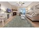 Bright living room with a stone fireplace, a ceiling fan and a sliding door to the patio at 7508 Hollowell Dr, Tampa, FL 33615