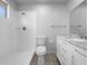 All-white bathroom featuring a shower with chrome fixtures, a toilet, and a vanity with a marble countertop at 804 Pineland Ave, Venice, FL 34285