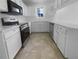 Modern kitchen featuring white cabinets, stainless steel appliances, and tile floors at 804 Pineland Ave, Venice, FL 34285